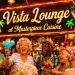 Neon Vista Lounge sign at Margaritaville Casino glowing over a lively bar area with people in tropical shirts.